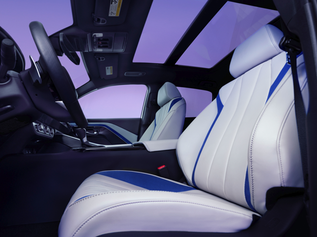 2025 Acura ADX car interior featuring white and blue leather seats and a panoramic sunroof.