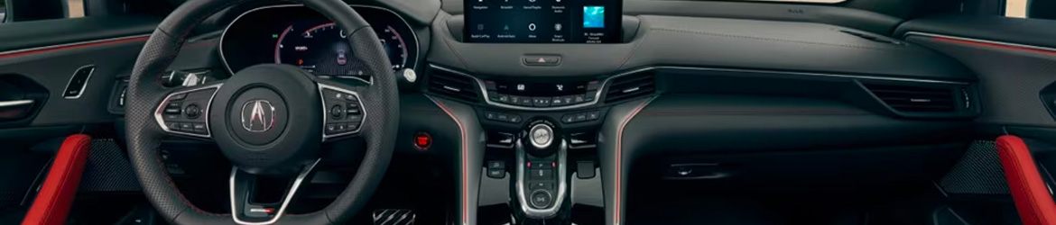 The interior of a 2025 Acura TLX car showing a black steering wheel, dashboard, and infotainment screen.