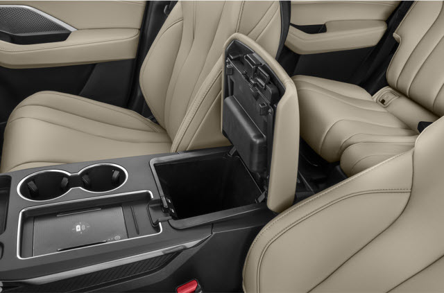 Tan leather 2026 Acura MDX interior with a center console, cupholders, and a storage compartment.